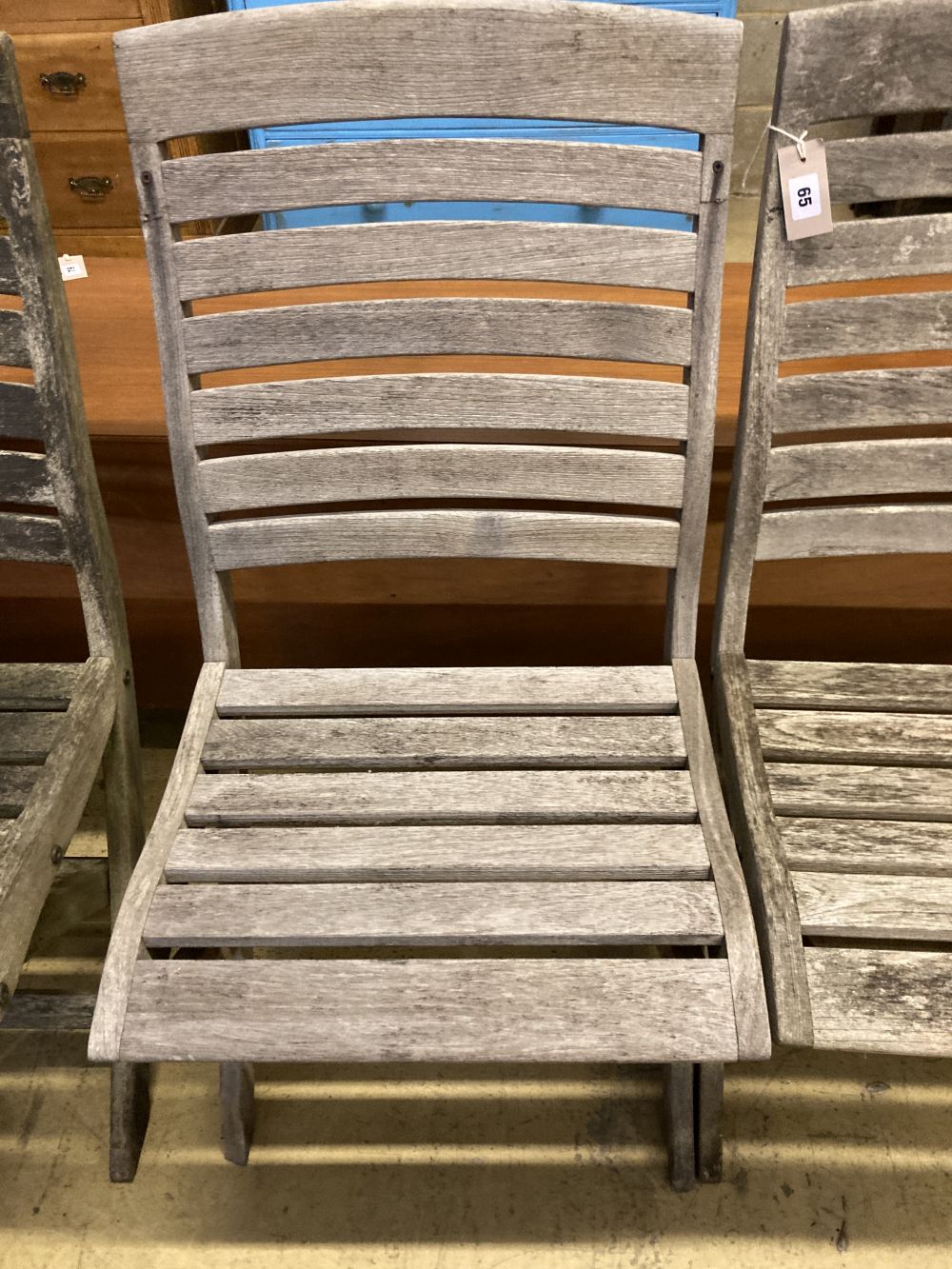 A set of four weathered teak folding garden chairs